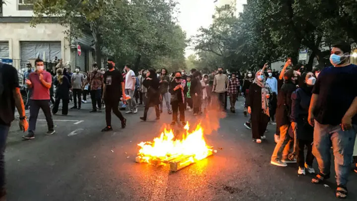 A fire burns on the streets of Iran as protesters continue to chant