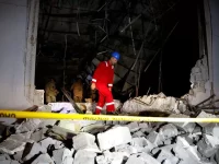 An emergency worker picks through rubble